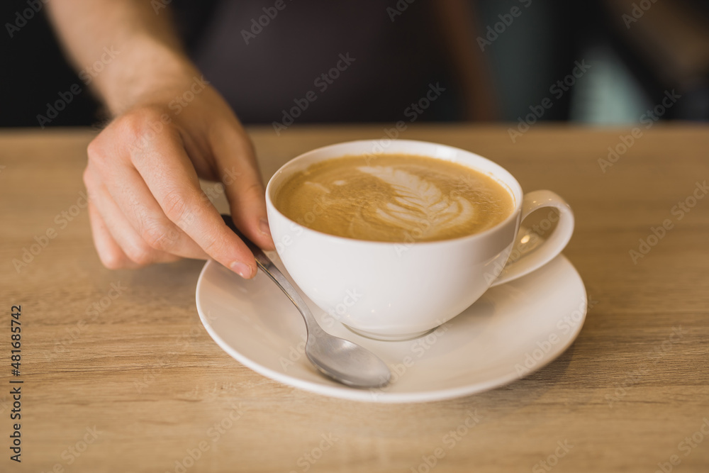 Barista with cup of coffee in cafe