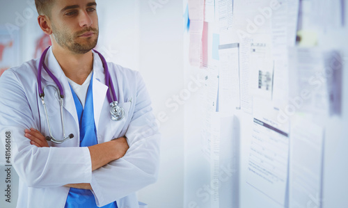 Young and confident male doctor portrait standing in medical office photo