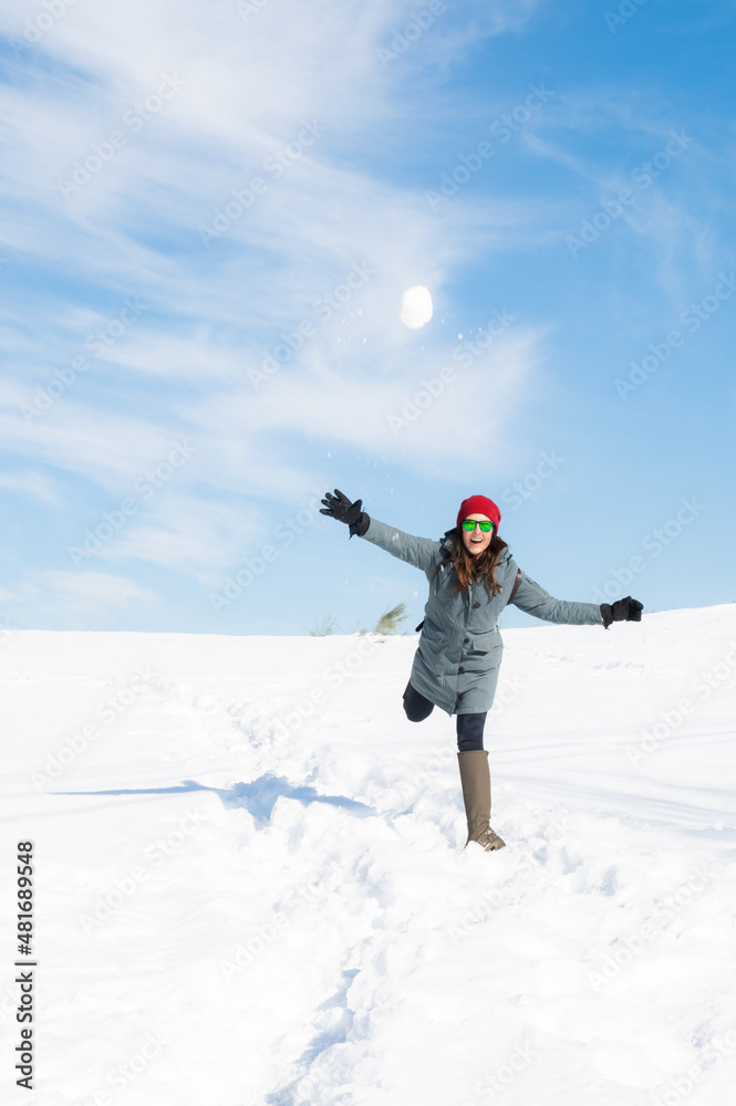 Nice girl enjoying a snowball fight in a sunny day