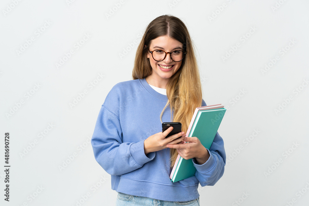Young blonde student woman isolated on white background sending a message with the mobile Young blonde student woman isolated on white background sending a message with the mobile