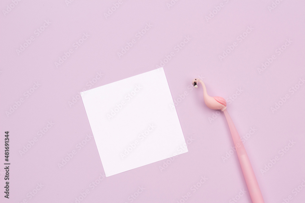 Blank white paper with flamingo shaped pen on lilac - pink background. space for text Blank white paper with flamingo shaped pen on lilac - pink background. space for text