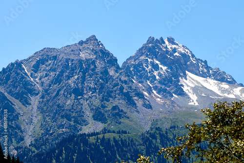 scenic view of the rocky mountain top and the slopes covered with forest