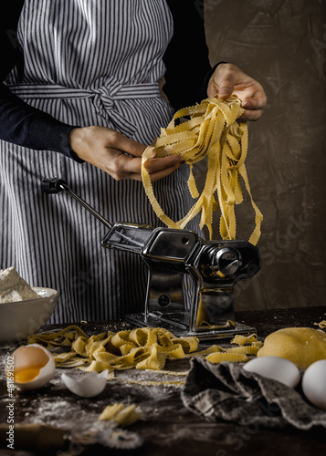 home made pasta machine with woman tagliatelli photo