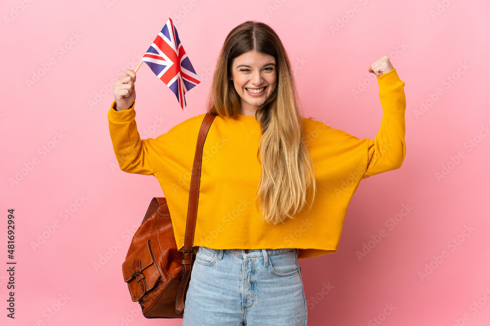 Young blonde woman holding an United Kingdom flag isolated on white background doing strong gesture - obrazy, fototapety, plakaty 