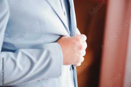 A man fastens buttons on his shirt.