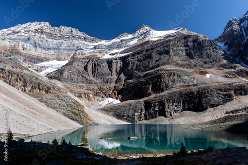 Vibrant blue glacial lake Oesa with snowy mountains in the background, Lake O'Hara, Yoho National Park, Canada. photo