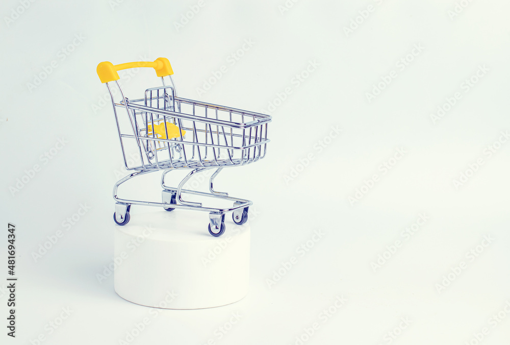 Mini shopping trolley on white podium. Online shopping, supermarket, store, sale concept