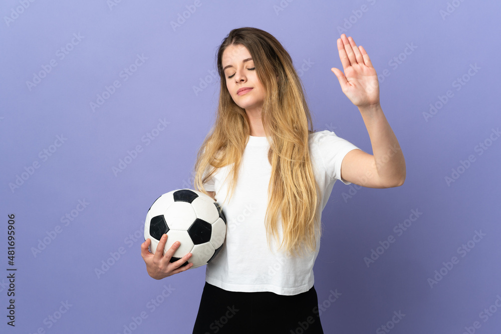 Young blonde football player woman isolated on purple background making stop gesture and disappointed Young blonde football player woman isolated on purple background making stop gesture and disappointed