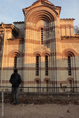 A male tourist examines an ancient, stone and beautiful temple.