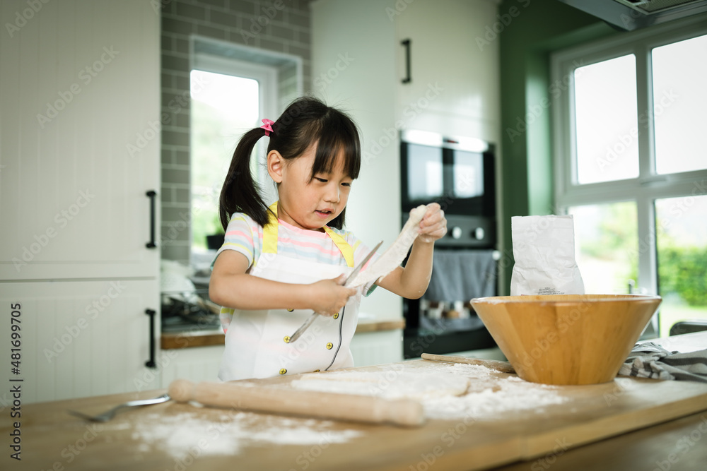 young girl making bread dough at home kitchen for home schooling