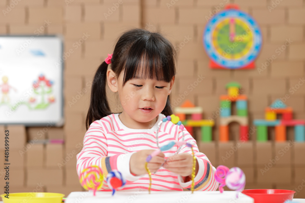 young girl making bead craft at home young girl making bead craft at home