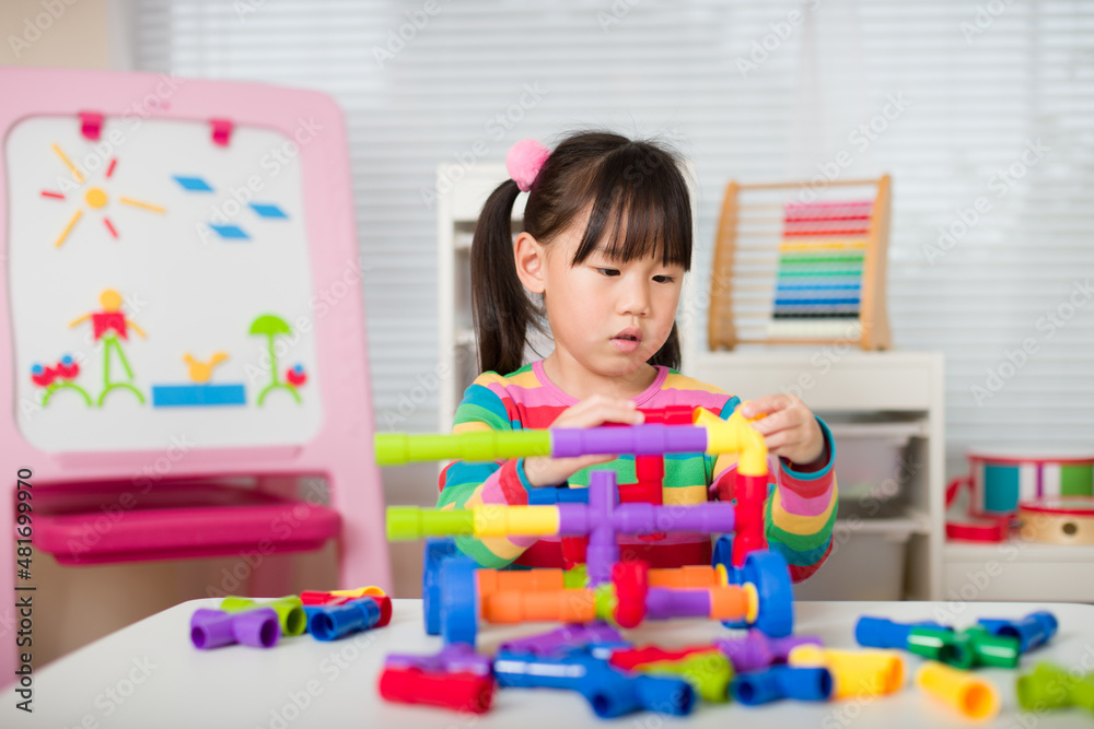young girl playing water pipe construsction toy at home young girl playing water pipe construsction toy at home