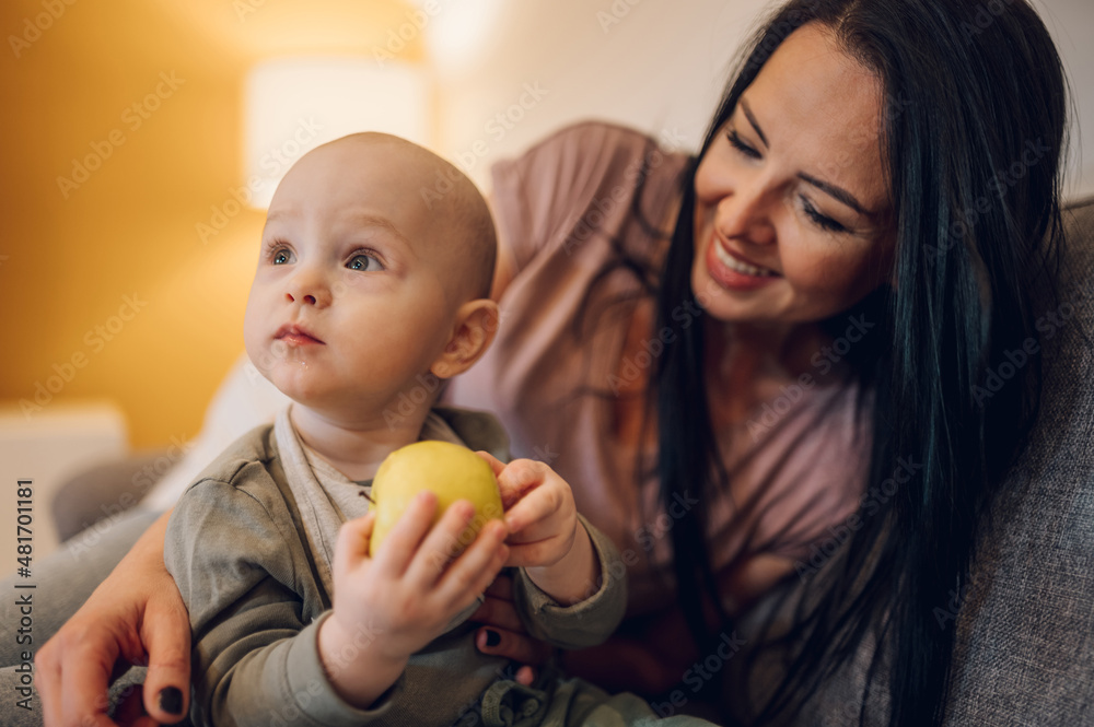 Happy mother and baby eating fresh fruit at home Happy mother and baby eating fresh fruit at home