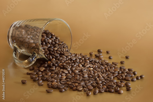 Follen cup of coffee. There are scattered coffee beans on the surface
