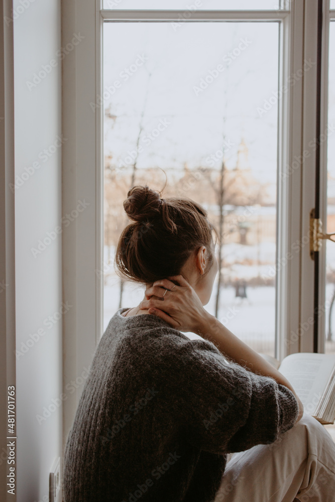 woman reading at home at the window woman reading at home at the window