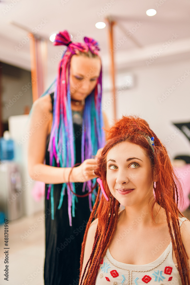 Hippie and boho style coiffure with kanekalon. Hairdresser with colored  afro braids weaves to funny redhead girl ginger dreadlocks. Beauty salon  services. Stock-Foto | Adobe Stock