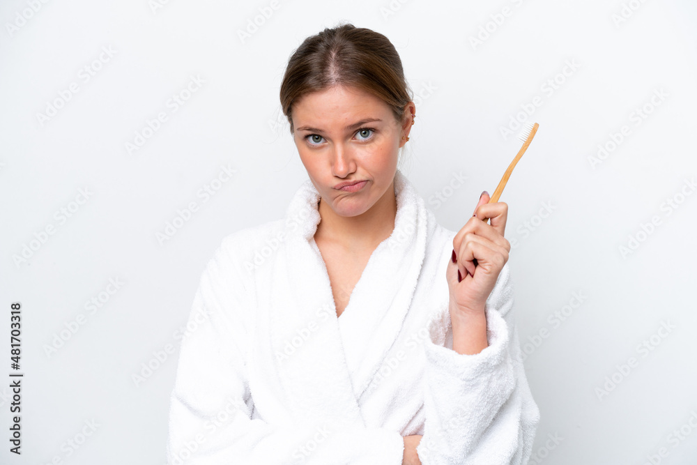 Young caucasian woman brushing teeth isolated on white background with sad expression Young caucasian woman brushing teeth isolated on white background with sad expression