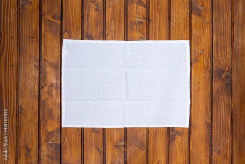 Top view of white napkin or dish towel on empty wooden table