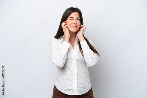 Young Brazilian woman isolated on white background frustrated and covering ears © luismolinero