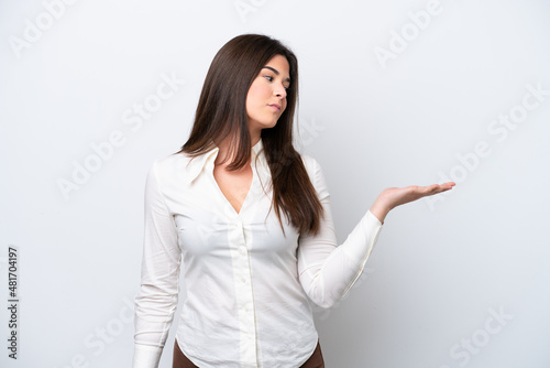Young Brazilian woman isolated on white background holding copyspace with doubts