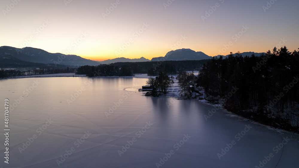 Wunderschöne Aufnahmen des zugefrorenen Faaker Sees + Insel in Österreich / Kärnten bei Sonnenuntergang - beautiful photograph of a frozen lake in Carinthia - Austria at sunset  -dji mavic 3 cine  4k 
