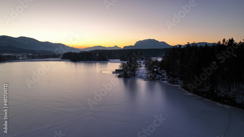Wunderschöne Aufnahmen des zugefrorenen Faaker Sees + Insel in Österreich / Kärnten bei Sonnenuntergang - beautiful photograph of a frozen lake in Carinthia - Austria at sunset -dji mavic 3 cine 4k 