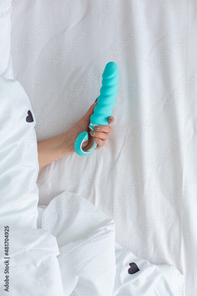 a woman's hand and a vibrator. sex toy a woman's hand and a vibrator. sex toy