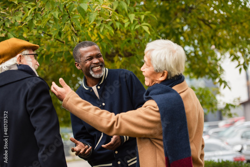 Positive elderly multiethnic friends talking on urban street. © LIGHTFIELD STUDIOS