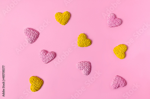 Four yellow and five pink hearts arranged in a square on pastel pink background. Minimal romantic concept for Valentine's celebration banner or card. Artistic design for wedding party invitation.