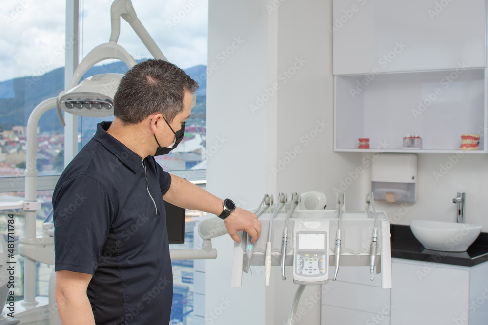 Dentist man preparing the clinical equipment for a consultation. Dental clinic concept Dentist man preparing the clinical equipment for a consultation. Dental clinic concept