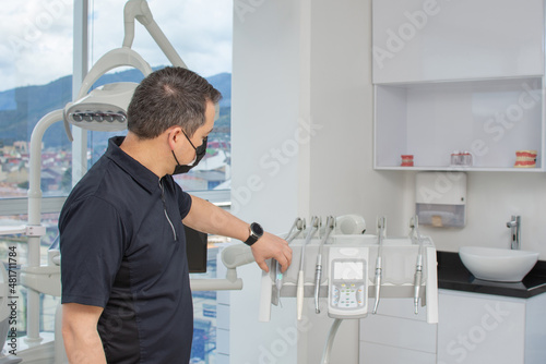 Dentist man preparing the clinical equipment for a consultation. Dental clinic concept