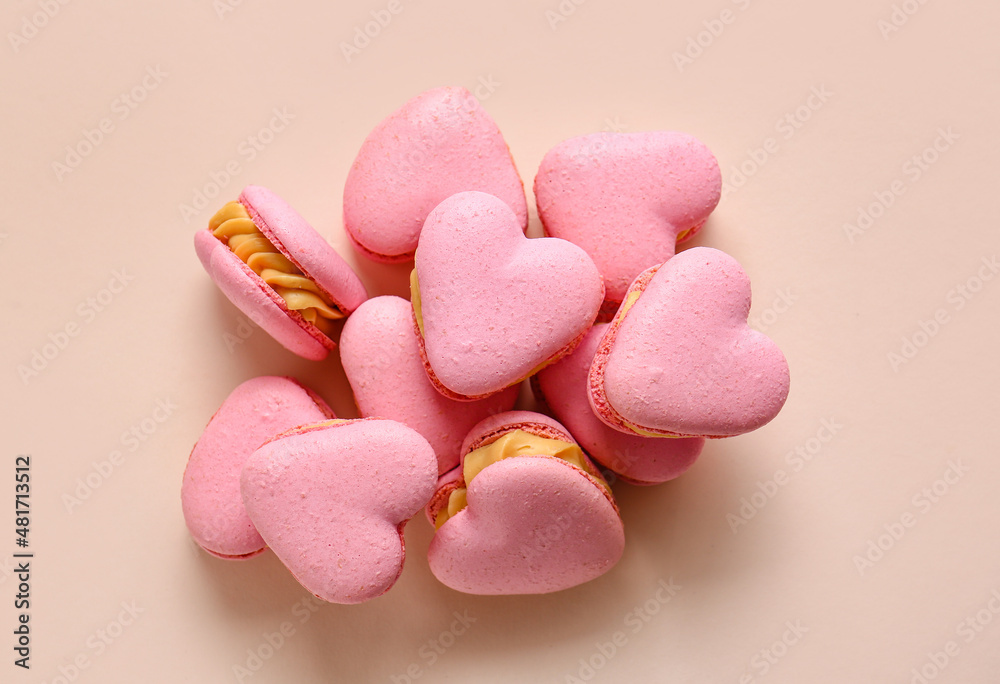 Obraz premium Tasty heart-shaped macaroons on beige background