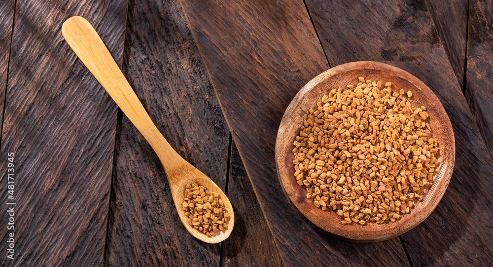 Fenugreek seeds in the wooden bowl - Healthy food Fenugreek seeds in the wooden bowl - Healthy food
