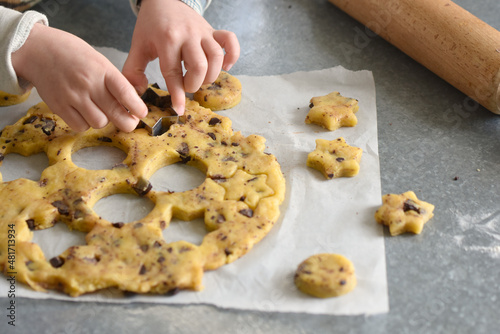 Child hands baking homemade chocolate cookie. Realization cookie workshop with dough and cookie cutters. Easy cooking close-up