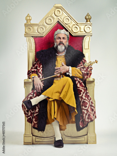 I took the throne peacefully. Studio shot of a richly garbed king sitting on a throne. photo