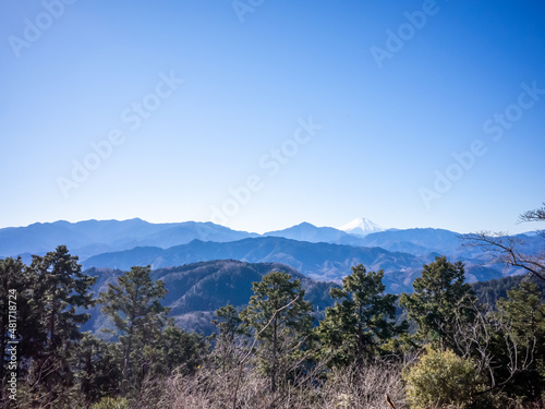 landscape of snow-covered top of mount fuji, mountain ranges, and blue clear sky