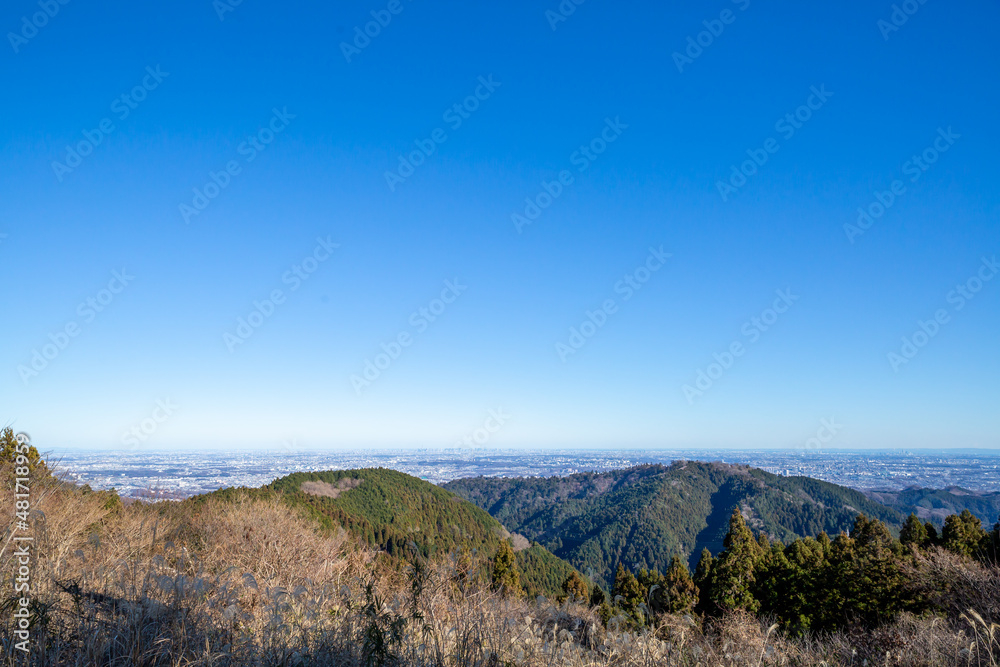 panorama cityscape of tokyo, mountain range, and clear blue sky seen from the top of kobotoke shiroyama mountain in japan