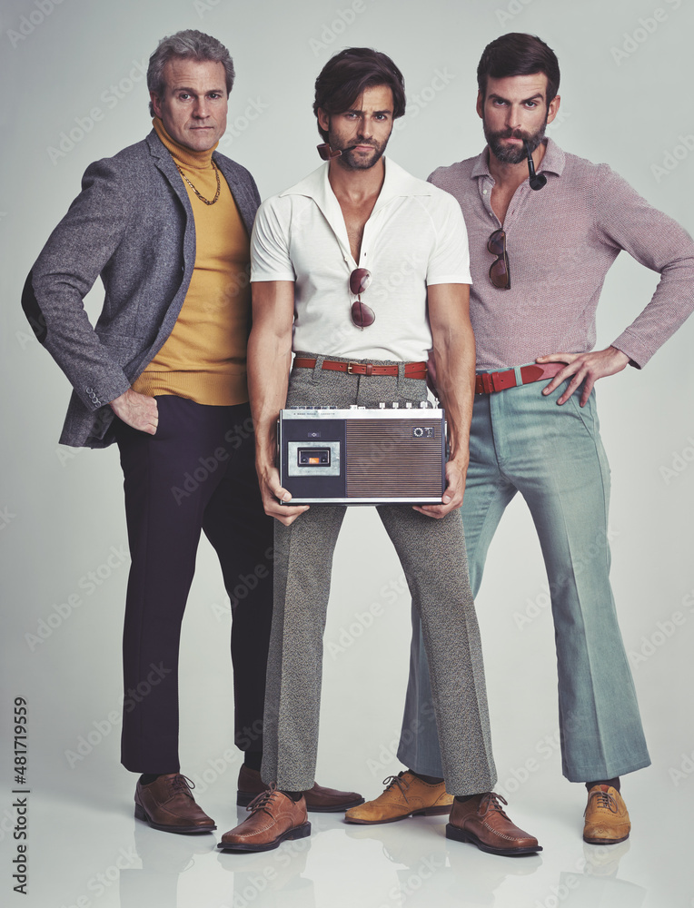 Premium Photo  Ready to kick it retro style. a studio shot of three men  clad in retro 70s wear holding a cassette player.