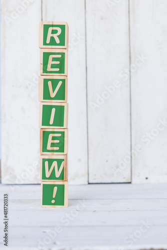 wooden cube, with the word review, on white background