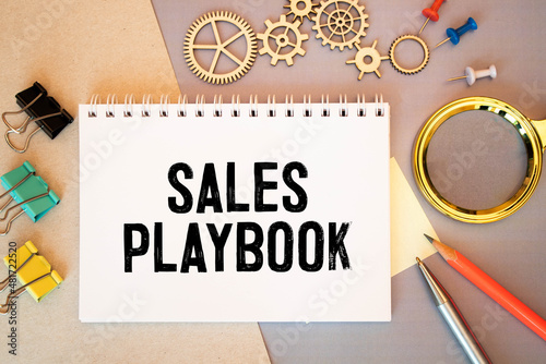sales playbook text on paper on the chart background with pen