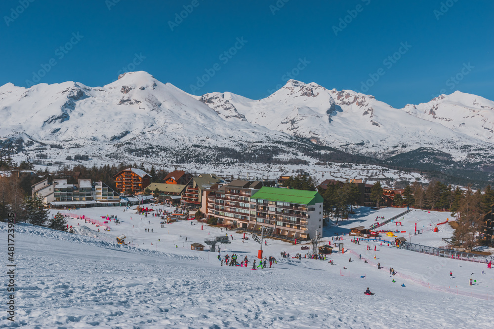 A picturesque landscape view of the snowcapped French Alps mountains and  the ski resort buildings on a cold winter day (La Joue du Loup, Devoluy)  Stock Photo | Adobe Stock