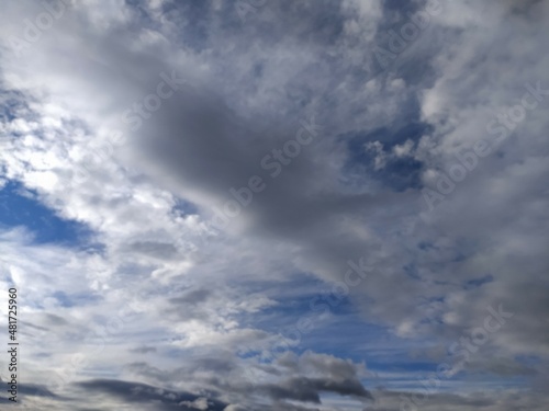 Clouds in the blue sky. Sky with gray and white clouds, background, thunderclouds, unstable changeable weather, storm clouds background.