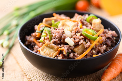 Fried purple rice with tofu, carrot, pumpkin and chili pepper. Healthy Asian vegan food