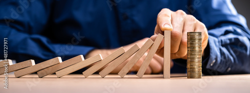 Foto Business Risk. Hand Stopping Falling Domino