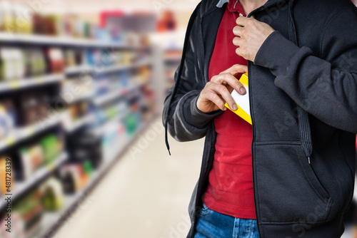 Retail Shoplifting. Man Stealing In Supermarket photo