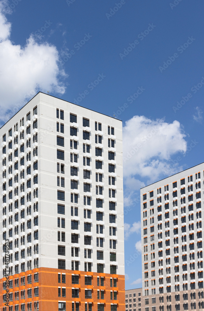 New modern residential apartment buildings newly build on blue cloudy sky New modern residential apartment buildings newly build on blue cloudy sky