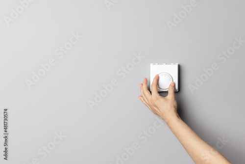 Woman Hand Adjusting or Turning On Off Wall Temperature Regulator Controller Button