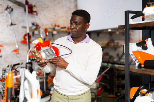 Foto Customer takes close look at new emery electric motor at a tool store