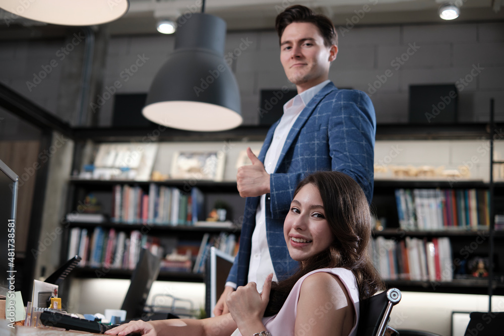 Portrait of happy beautiful female worker and handsome Caucasian male colleague looking at the camera, cheerful and thumbs up in business office workspace lifestyle, creative professional occupation. Portrait of happy beautiful female worker and handsome Caucasian male colleague looking at the camera, cheerful and thumbs up in business office workspace lifestyle, creative professional occupation.