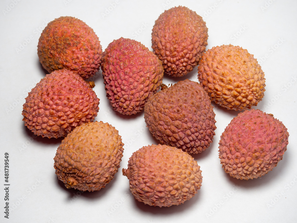 Lychee on the table. Chinese plum on a white background. Ripe fruit from Asia. Delicious, juicy product.